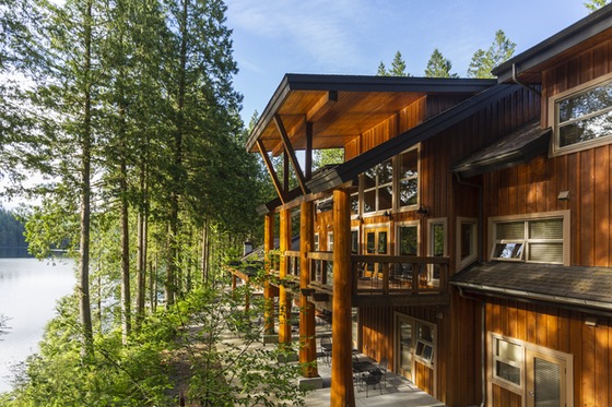 Wooden conference building above a forested lake